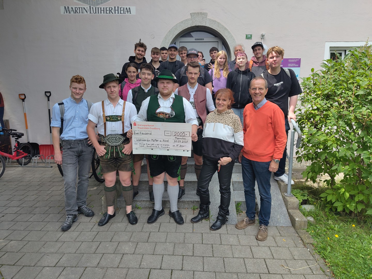 Das Foto zeigt Schülerinnen und Schüler der 10. Klasse Metallbau der Berufsschule I Traunstein bei der Übergabe des symbolischen Spendenschecks. Von rechts: Koordinator der Aktion „Eine Welt und Not im eigenen Land“ Franz Deser, Einrichtungsleitung Veronika Kecht, Klassensprecher Thomas Golser und Klassensprecher Vinzenz Eglseer mit Schülerinnen, Schülern und Lehrkräften der Berufsschulklasse.