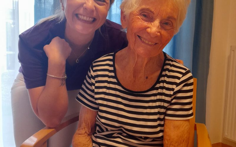Endlich wieder zufrieden: Pflegehelferin Indira freut sich mit unserer Bewohnerin über die gelungene Aktion.
