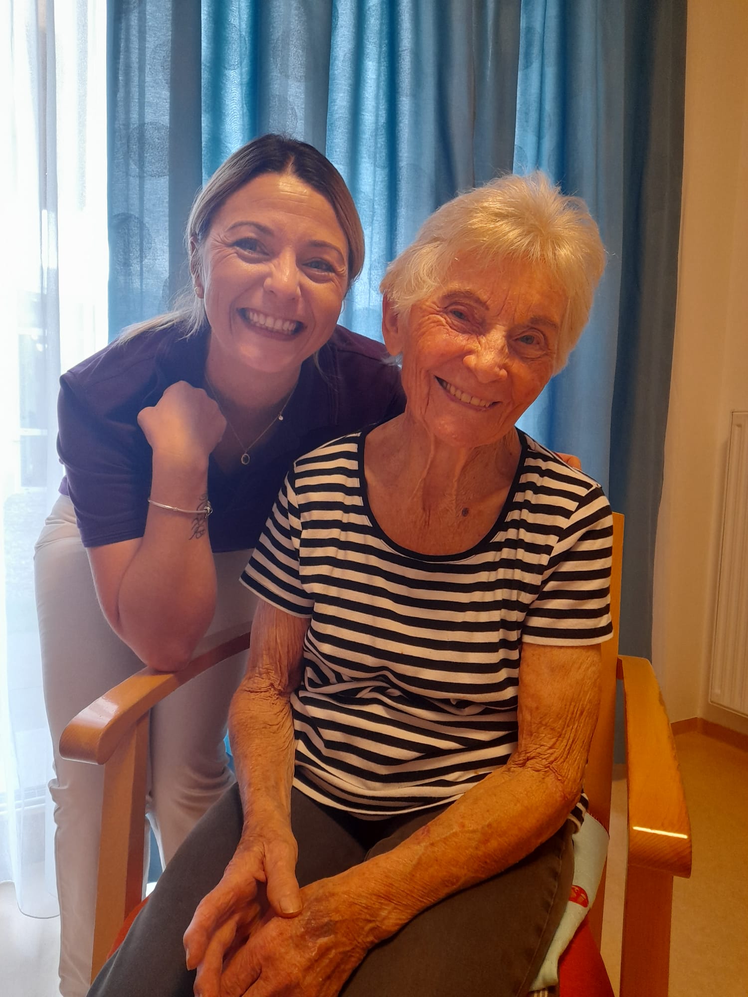 Endlich wieder zufrieden: Pflegehelferin Indira freut sich mit unserer Bewohnerin über die gelungene Aktion.