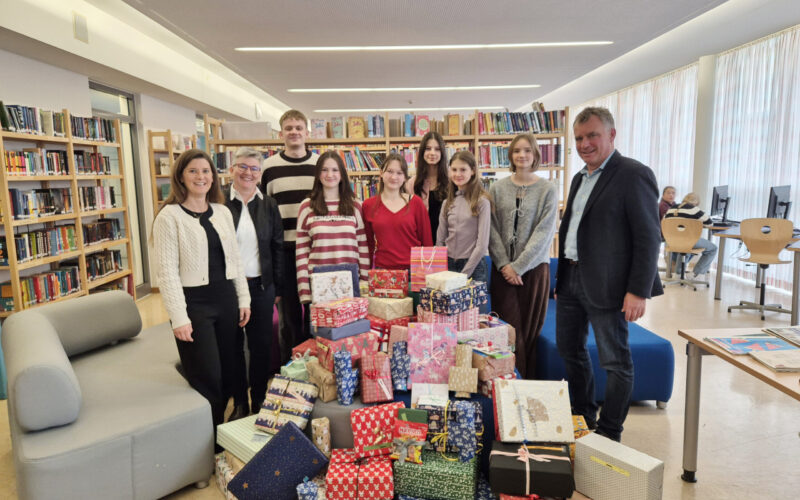 Von rechts: Schulleiter Diether Thumser freut sich gemeinsam mit den Schülerinnen und Schülern, Oberstudienrätin Ute Heim und der stellvertretenden Heimleiterin Elisabeth Brich über 71 Weihnachtsgeschenke für Kinder und Jugendliche des Wilhelm-Löhe-Heims Traunreut.