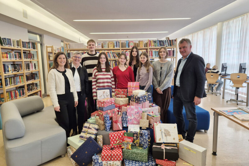 Von rechts: Schulleiter Diether Thumser freut sich gemeinsam mit den Schülerinnen und Schülern, Oberstudienrätin Ute Heim und der stellvertretenden Heimleiterin Elisabeth Brich über 71 Weihnachtsgeschenke für Kinder und Jugendliche des Wilhelm-Löhe-Heims Traunreut.