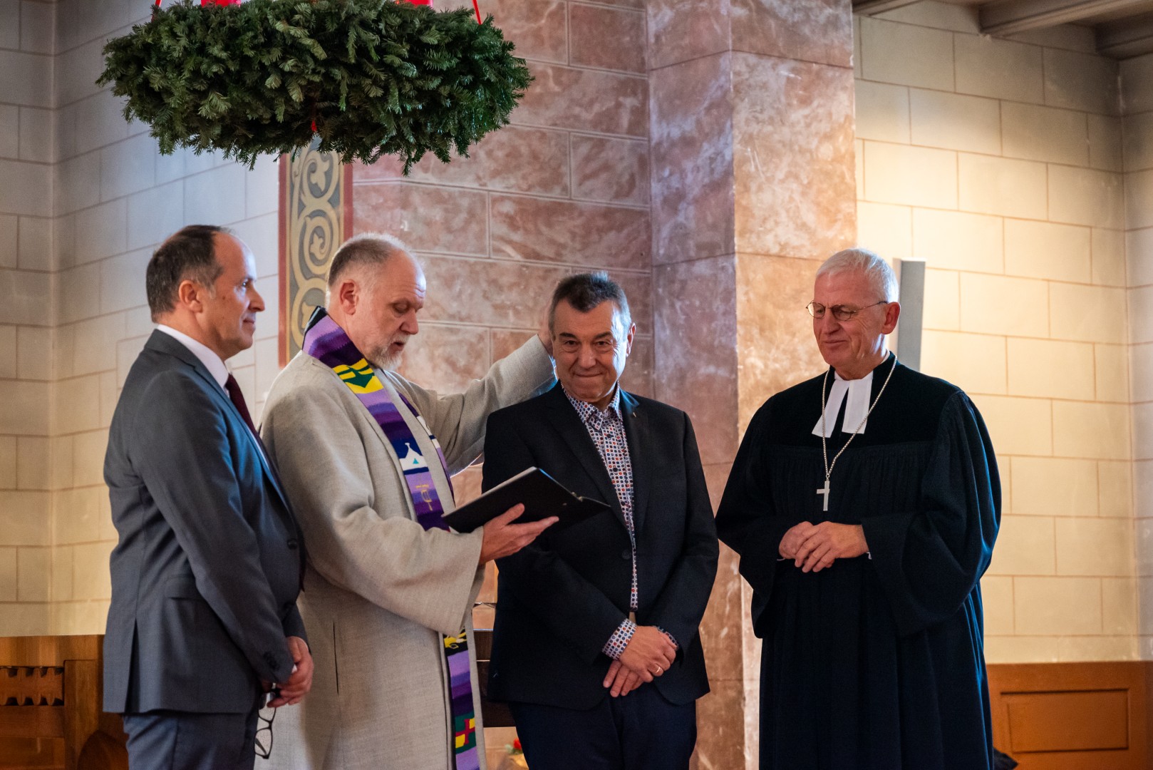 von links: Andreas Karau, Peter Barbian und Dekan Peter Bertram (rechts) entpflichten Robert Münderlein von seinen Aufgaben.