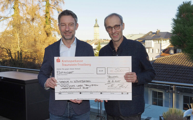 (von links): Roger Pawellek, Vorstandsvorsitzender der Kreissparkasse Traunstein-Trostberg, überreicht Diakon Michael Sörgel von der Diakonie einen symbolischen Spendenscheck über 500 Euro für Menschen in Notlagen.