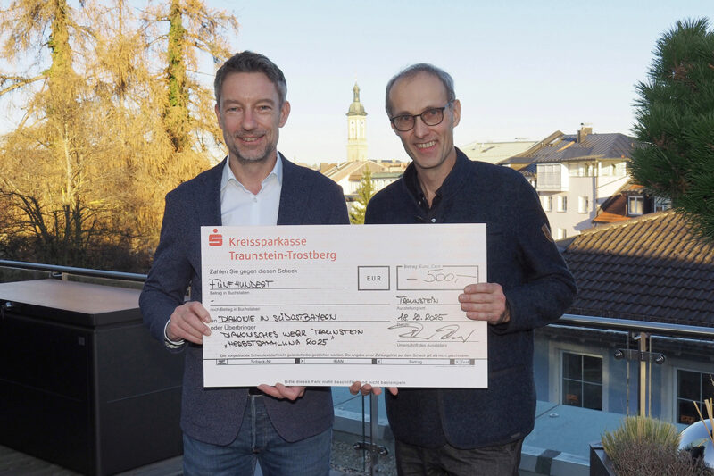 (von links): Roger Pawellek, Vorstandsvorsitzender der Kreissparkasse Traunstein-Trostberg, überreicht Diakon Michael Sörgel von der Diakonie einen symbolischen Spendenscheck über 500 Euro für Menschen in Notlagen.