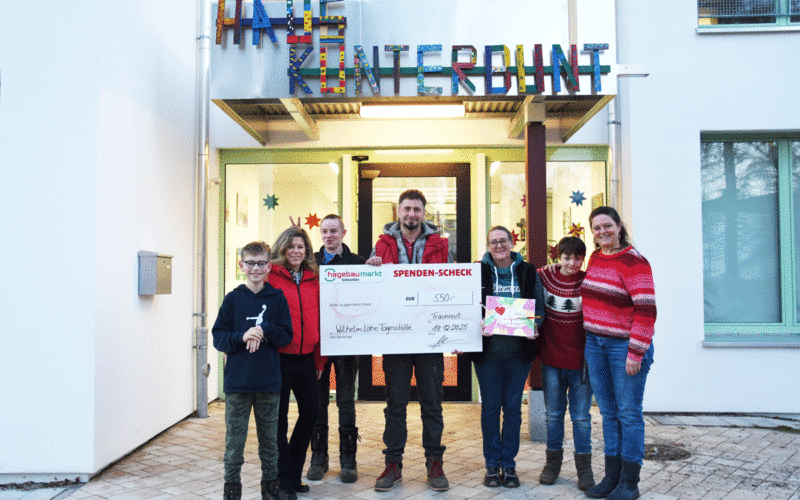 Ingo Berghammer (Bildmitte) und die stellvertretende Marktleitung Winni Bissen (dritte von rechts) vom Hagebaumarkt Schneider Traunreut überreichen Julia Fakler (rechts), Gisela Auner (zweite von links) sowie Kindern der Wilhelm-Löhe-Tagesstätte einen symbolischen Spendenscheck über 550 Euro.