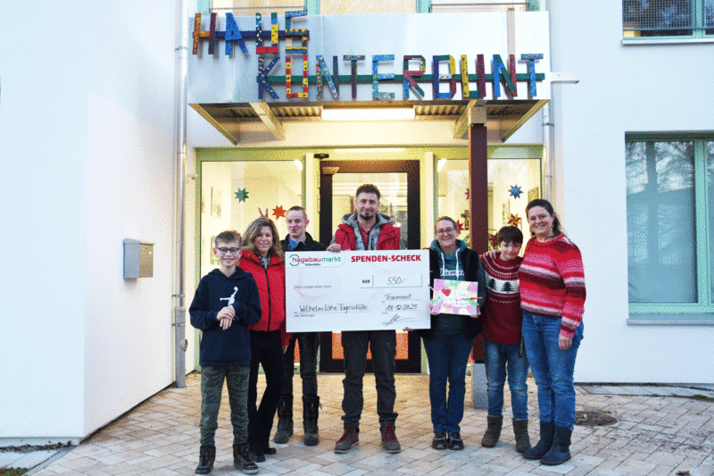Ingo Berghammer (Bildmitte) und die stellvertretende Marktleitung Winni Bissen (dritte von rechts) vom Hagebaumarkt Schneider Traunreut überreichen Julia Fakler (rechts), Gisela Auner (zweite von links) sowie Kindern der Wilhelm-Löhe-Tagesstätte einen symbolischen Spendenscheck über 550 Euro.