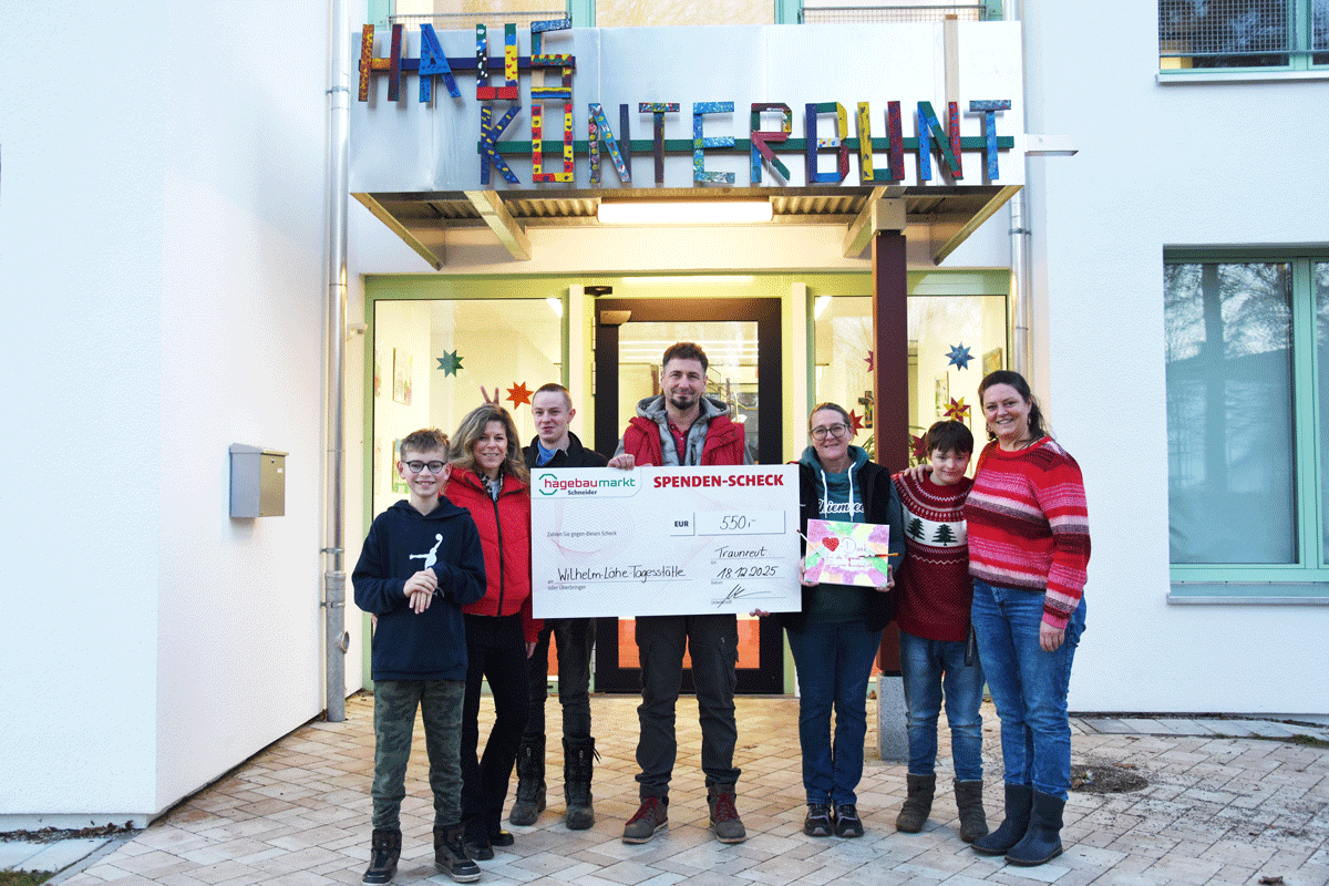 Ingo Begmann (Bildmitte) und die stellvertretende Marktleitung Winni Bissen (dritte von rechts) vom Hagebaumarkt Schneider Traunreut überreichen Julia Fakler (rechts), Gisela Auner (zweite von links) sowie Kindern der Wilhelm-Löhe-Tagesstätte einen symbolischen Spendenscheck über 550 Euro.