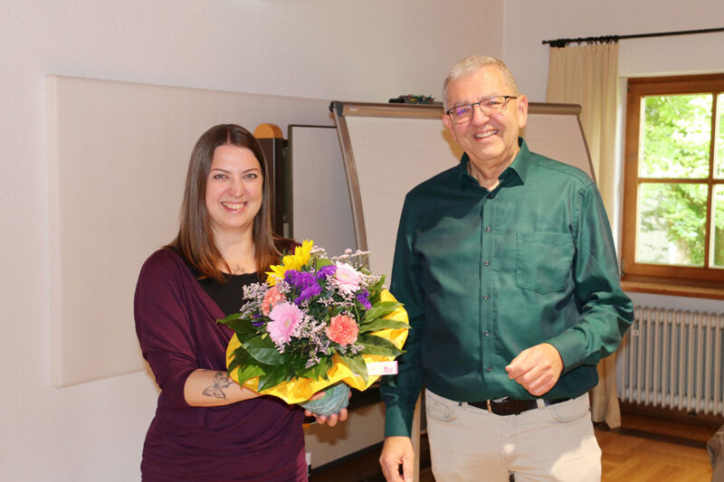 Bereichsleiter Klaus Rieder begrüßt Tanja Quisinsky an ihrem ersten Arbeitstag mit einem Blumenstrauß. Im Anschluss konnte sie bereits viele ihrer künftigen Kolleginnen und Kollegen persönlich kennenlernen, da an diesem Tag eine Mitarbeitendenbesprechung der Geschäftsstelle im Tagungshaus St. Rupert stattfand.