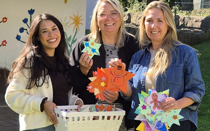 250 Sterne, die Wünsche wahr werden lassen: Maike Zimmermann, Geschäftsbereichsleiterin der Kindertagesstätten, und Melanie Janisch von „Spenden und Helfen“ überreichen Birgit Sailer von Vergissmeinnicht Chiemgau e.V. die liebevoll und farbenfroh gestalteten Sterne für die diesjährige Wunschbaumaktion.